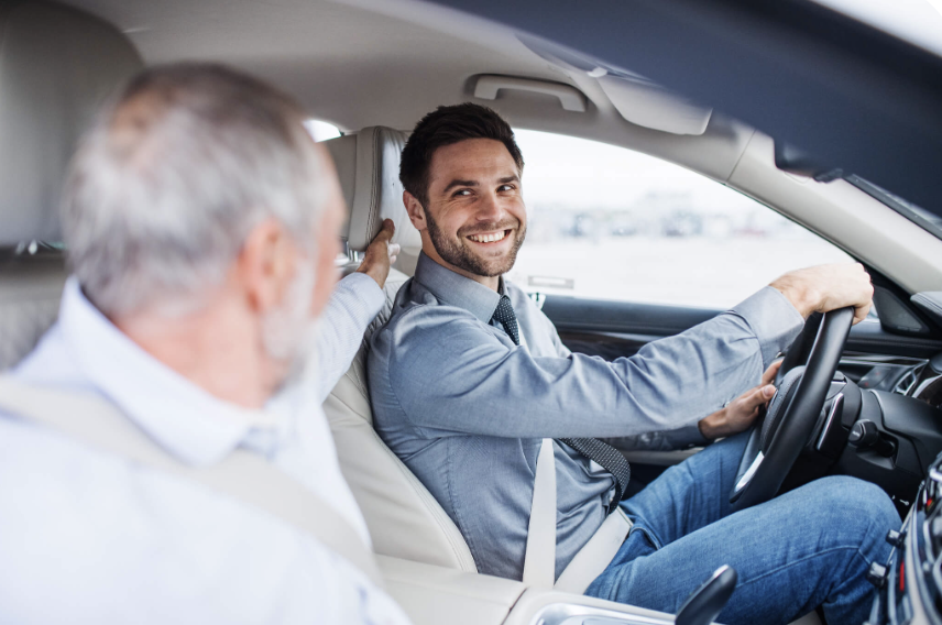 A caregiver driving an older client with a reassuring smile on the way to an appointment.